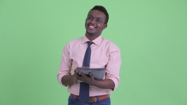 快乐的年轻非洲商人思考，而使用数字平板电脑 — 图库视频影像