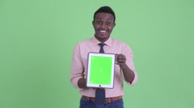 Mutlu genç Afrikalı işadamı dijital tablet gösterirken konuşuyor