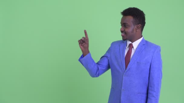 Ευτυχισμένος νέος Αφρικανός επιχειρηματίας αγγίζοντας κάτι — Αρχείο Βίντεο