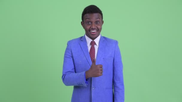 Счастливый молодой африканский бизнесмен подает большие пальцы — стоковое видео