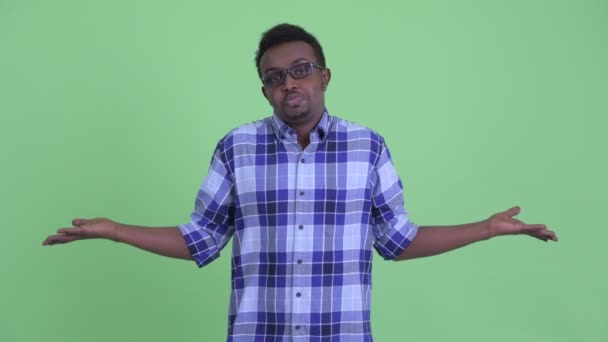 Confused young African hipster man shrugging shoulders — Stock Video