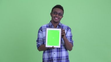 Mutlu genç Afrikalı hipster adam dijital tablet gösterirken düşünme