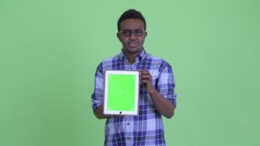 Mutlu genç Afrikalı hipster adam dijital tablet gösterirken konuşuyor