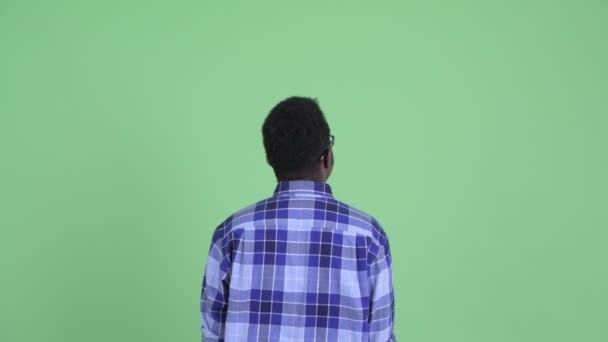 Rear view of young African hipster man pointing finger — Stock Video