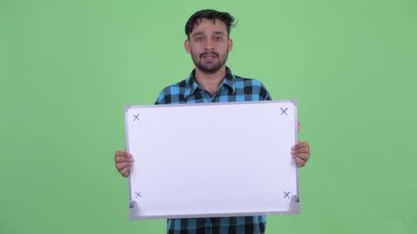 Gelukkige jonge bebaarde Perzische hipster man praten terwijl het houden van Whiteboard — Stockvideo