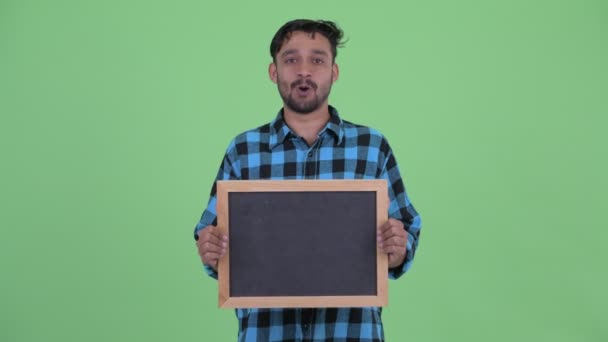 Feliz jovem barbudo persa hipster homem falando enquanto segurando blackboard — Vídeo de Stock