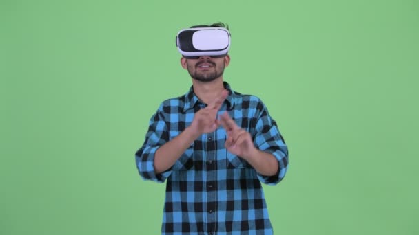 Счастливый молодой бородатый персидский хипстер, использующий гарнитуру виртуальной реальности — стоковое видео