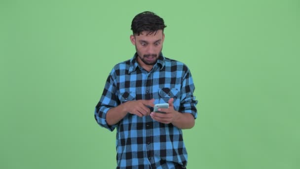 Ευτυχισμένος νέος μουσάτος περσικός άντρας χρησιμοποιώντας το τηλέφωνο και αναζητούν έκπληκτος — Αρχείο Βίντεο