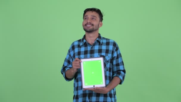 Heureux jeune barbu perse hipster homme penser tout en montrant tablette numérique — Video
