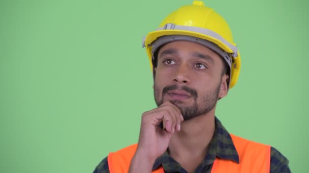 Rostro de feliz joven barbudo Persa trabajador de la construcción pensando y mirando hacia arriba — Vídeos de Stock