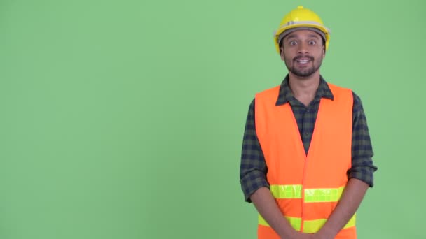 Ευτυχισμένος νέος μουσάτος περσικός εργάτης κατασκευών που δείχνει στο πίσω μέρος — Αρχείο Βίντεο