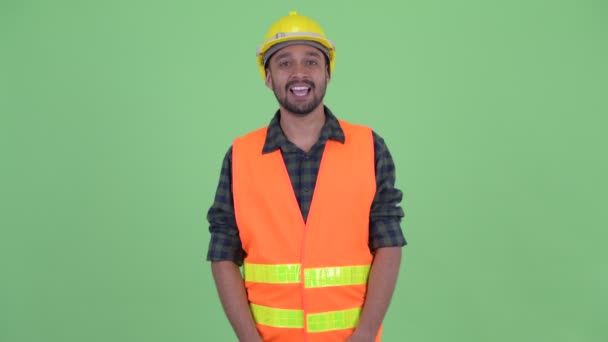 Szczęśliwy młody Brodaty Perski pracownik budowlany prezentacji czegoś — Wideo stockowe