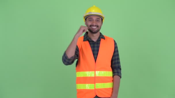 Feliz joven barbudo persa trabajador de la construcción recibiendo buenas noticias — Vídeos de Stock