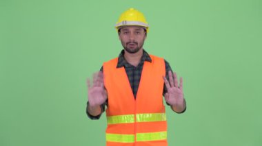Genç sakallı Pers adam inşaat işçisi el hayır sallayarak