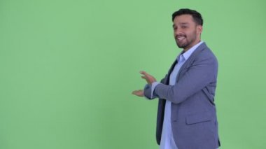 Mutlu genç sakallı İranlı işadamı arka gösteren