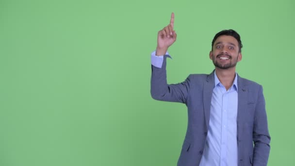 Boldog fiatal szakállas perzsa üzletember gondolkodás és a felfelé mutató — Stock videók