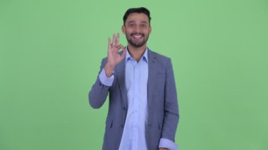 Ok işareti ile Mutlu genç sakallı İranlı işadamı