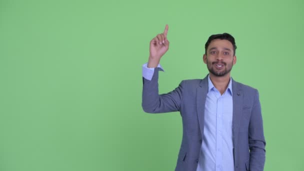 Lycklig ung skäggiga Persiska affärsman pratar medan pekar uppåt — Stockvideo