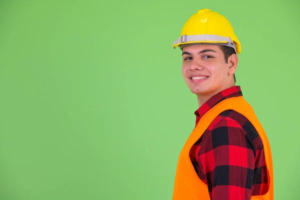 Kameraya bakan mutlu genç çok ırklı adam inşaat işçisiprofil görünümü — Stok fotoğraf