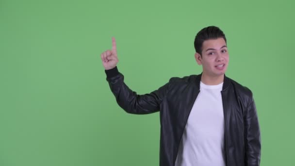 Mutlu genç yakışıklı çok etnik adam yukarı işaret ederken konuşurken — Stok video
