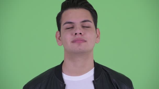 Лицо счастливого молодого красивого многонационального мужчины расслабляющего с закрытыми глазами — стоковое видео
