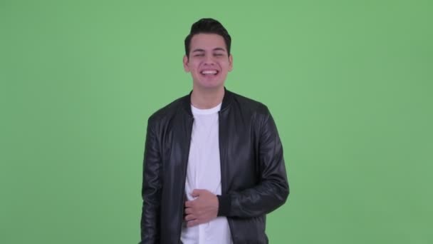 Glücklicher junger gutaussehender multiethnischer Mann, der lacht und in die Kamera zeigt — Stockvideo