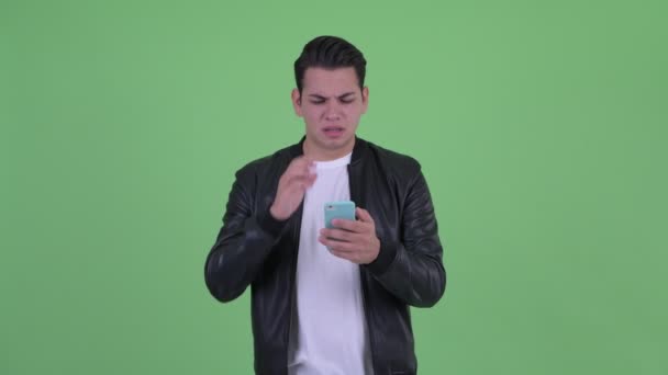 Estresado joven multi étnico hombre usando el teléfono y recibiendo malas noticias — Vídeo de stock