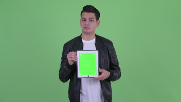 Gestresster junger multiethnischer Mann zeigt digitales Tablet — Stockvideo
