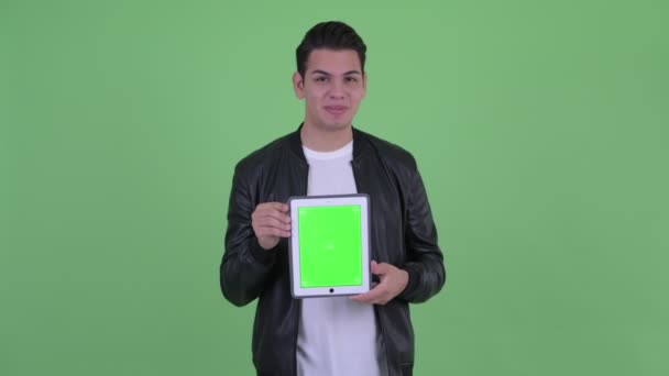 Jovem feliz bonito multi homem étnico falando enquanto mostra tablet digital — Vídeo de Stock