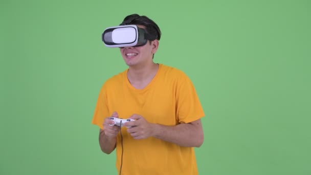 Gelukkig jonge multi etnische man spelen games tijdens het gebruik van Virtual Reality headset — Stockvideo