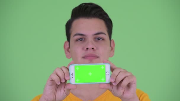 Cara de feliz joven multi étnico hombre pensando mientras muestra el teléfono — Vídeo de stock