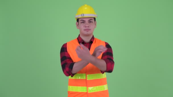 Heureux jeune homme multi ethnique travailleur de la construction souriant avec les bras croisés — Video