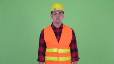 Stresli genç çok ırklı adam inşaat işçisi aşağı başparmak veren