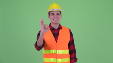 Ok işareti ile Mutlu genç çok etnik adam inşaat işçisi