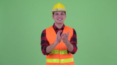 Mutlu genç çok etnik adam inşaat işçisi el çırpma