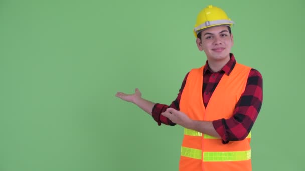 Gelukkige jonge multi etnische man bouwvakker die aan de achterzijde wordt getoond — Stockvideo