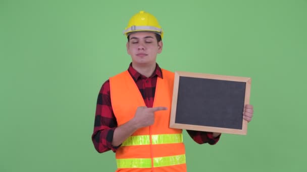 Stressé jeune homme multi ethnique travailleur de la construction tenant tableau noir et donnant pouces vers le bas — Video