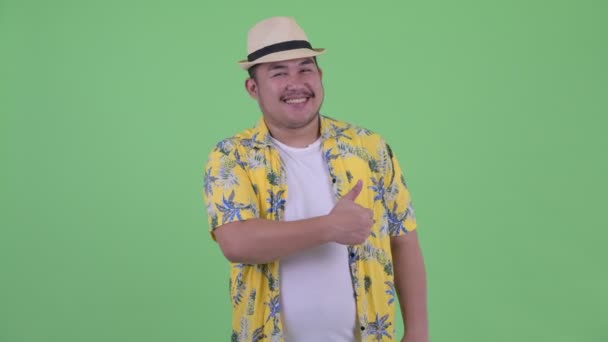 Mutlu genç kilolu Asyalı turist adam başparmak veren — Stok video