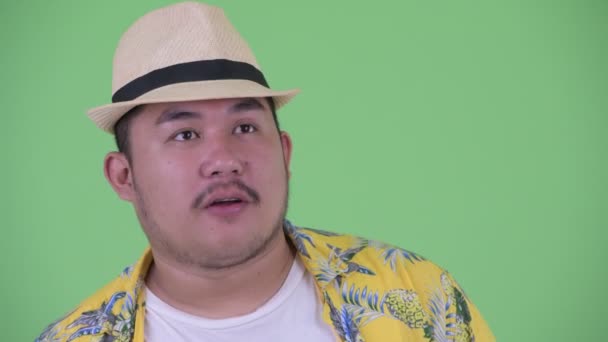 Лицо счастливого молодого толстого азиатского туриста, получающего хорошие новости — стоковое видео