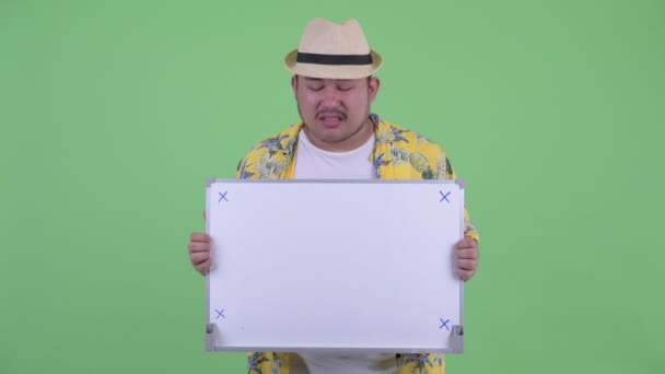 ホワイトボードを持つ若い太りすぎのアジアの観光客の男性を強調 — ストック動画