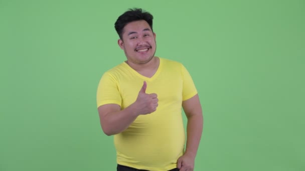 Felice giovane sovrappeso asiatico uomo dando pollici fino — Video Stock