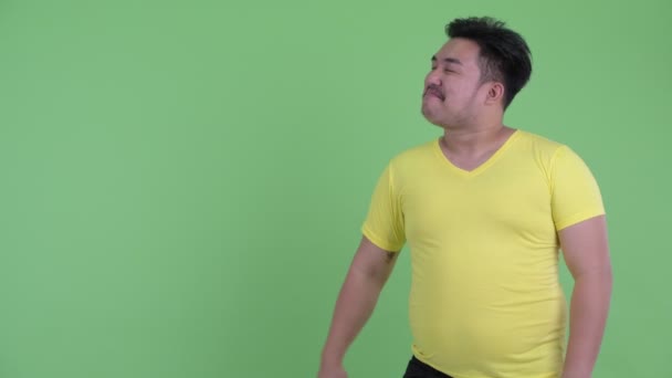 Gelukkig jong overgewicht Aziatische man snappen vingers en op zoek verrast — Stockvideo