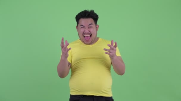 幸せな若い太りすぎのアジアの男性は驚いて見える — ストック動画