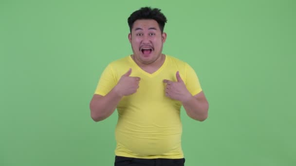 행복한 젊은 과체중 아시아 남자 웃고 가리키는 에 카메라 — 비디오