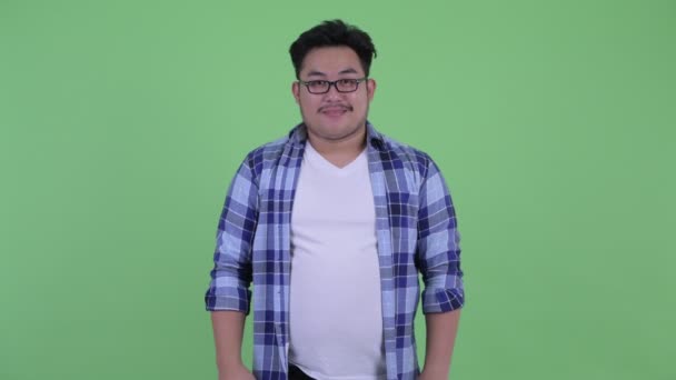 Happy young overweight Asian hipster man smiling — Stock Video