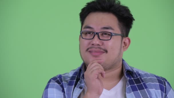 Gesicht des glücklichen jungen übergewichtigen asiatischen Hipster-Mannes, der denkt und nach oben schaut — Stockvideo