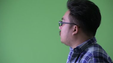 Mutlu genç kilolu Asya hipster adam gülümseyen Closeup profil görünümü