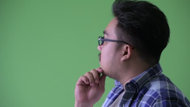 Gros plan profil vue de heureux jeune en surpoids asiatique hipster homme pensée — Video