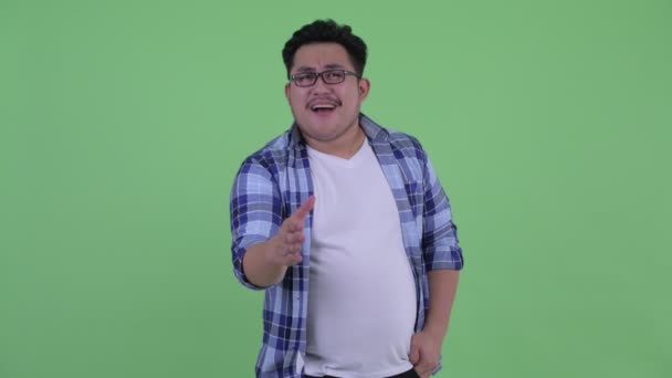 Boldog fiatal túlsúlyos ázsiai csípő ember, amely kézfogás — Stock videók