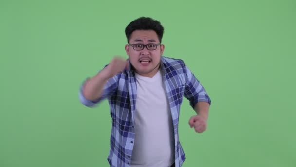 Glücklich junge übergewichtige asiatische Hipster-Mann immer gute Nachrichten — Stockvideo